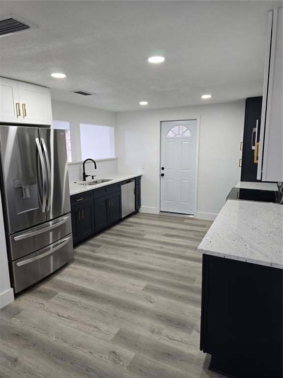 13737 Michelle Avenue Hudson, FL 34667 - Photo 4 of 25 a large kitchen with kitchen island a sink stainless steel appliances and cabinets