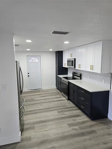 a kitchen with stainless steel appliances granite countertop a refrigerator and a stove top oven