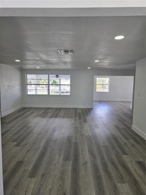 13737 Michelle Avenue Hudson, FL 34667 - Photo 10 of 25 an empty room with wooden floor and windows