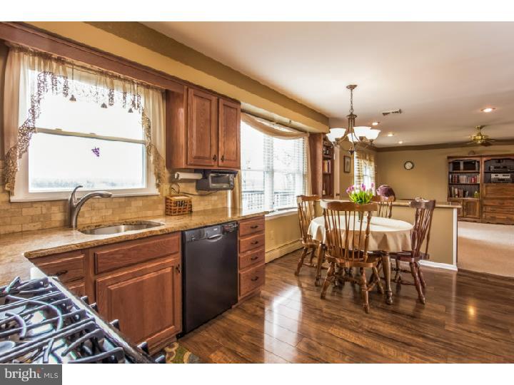 27274 Mt Pleasant Road Columbus, NJ 08022 - Photo 8 of 25 a kitchen with stainless steel appliances granite countertop a stove top oven a sink a dining table and chairs with wooden floor