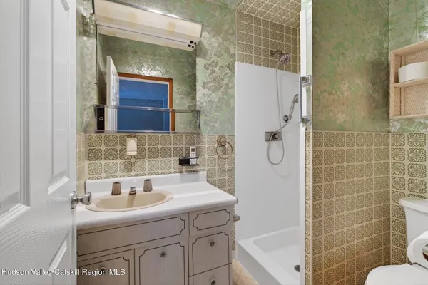 a bathroom with a sink vanity mirror and toilet