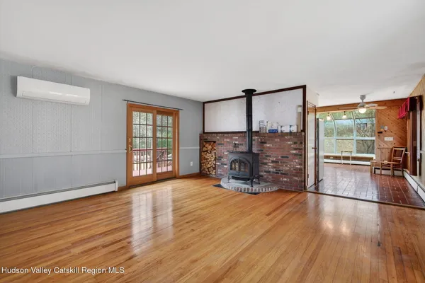 a view of empty room with wooden floor and fireplace