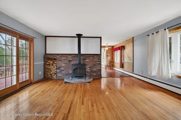 a view of empty room with wooden floor and fan