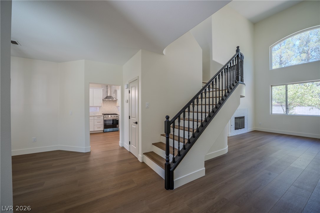 1832 Spring Summit Lane Las Vegas, NV 89134 - Photo 12 of 52 A spacious entry features gleaming wood flooring, an elegant staircase, and a glimpse of the modern kitchen.