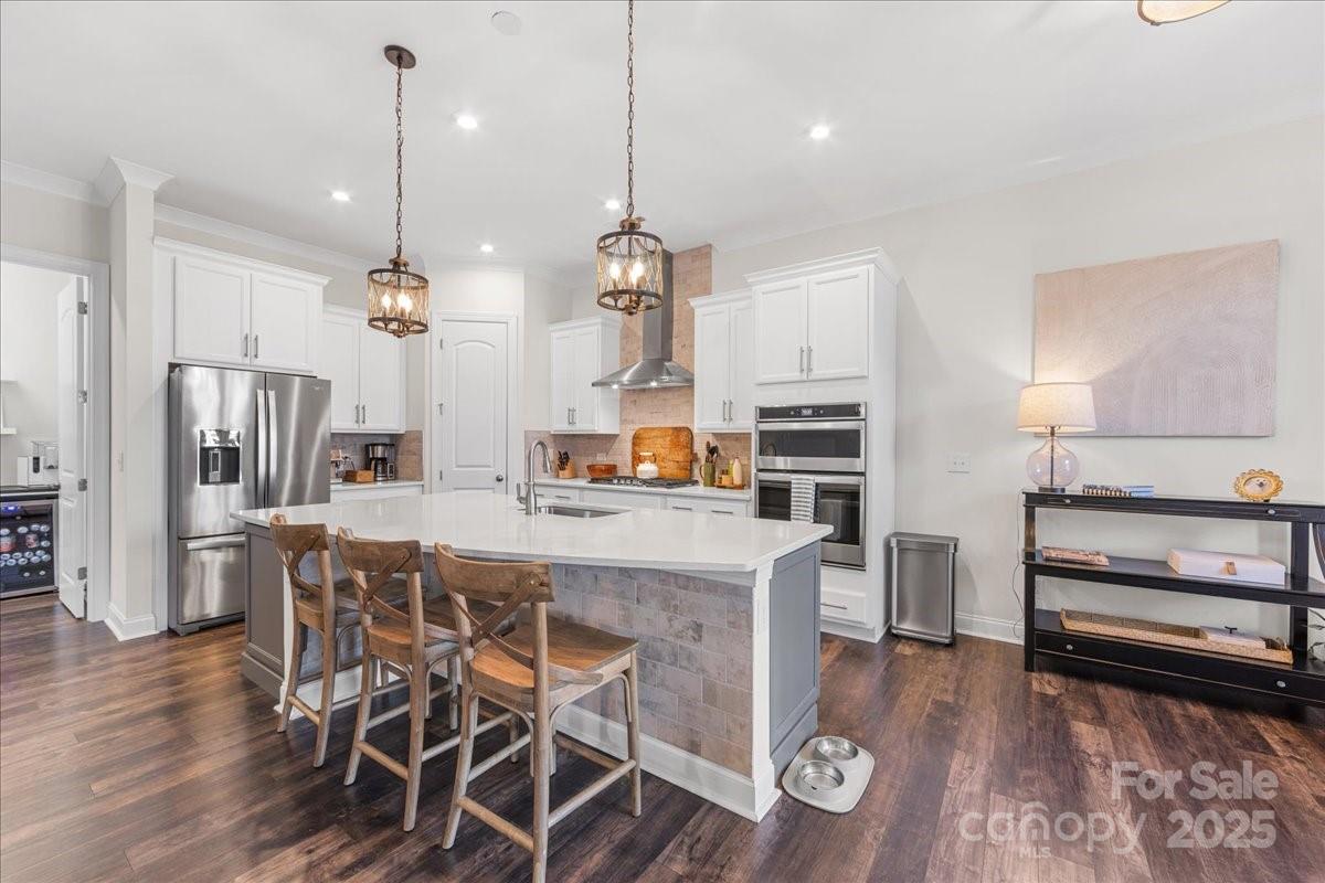 11413 Miller Road Pineville, NC 28134 - Photo 5 of 45 a kitchen with stainless steel appliances a dining table chairs stove and refrigerator