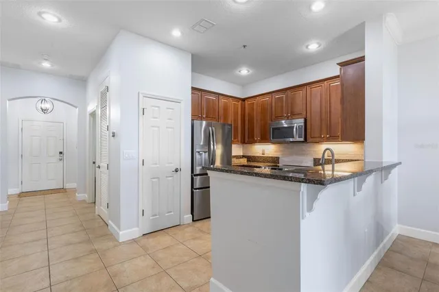 a kitchen with stainless steel appliances granite countertop a refrigerator stove and microwave