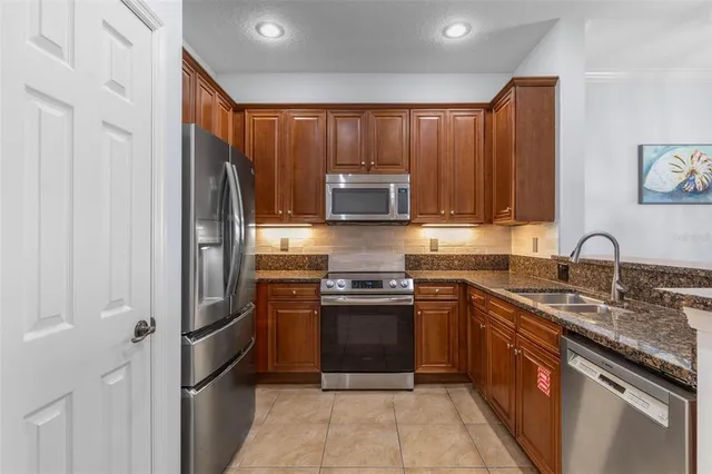 a kitchen with granite countertop a sink stainless steel appliances and cabinets