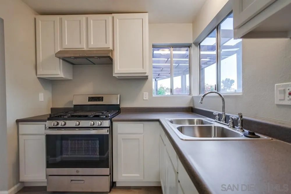 4729 Sunrise Ridge Oceanside, CA 92056 - Photo 7 of 22 a kitchen with granite countertop a stove a sink and a microwave