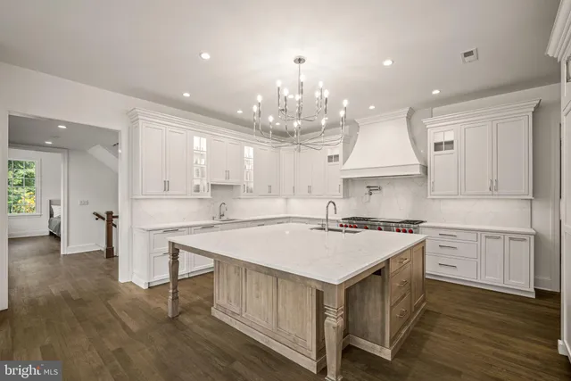 an empty room with windows a fireplace and wooden floor