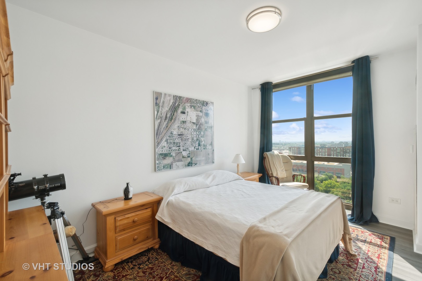 1101 South State Street, Unit 1800 Chicago, IL 60605 - Photo 10 of 18 a bedroom with a bed and a dresser next to a window