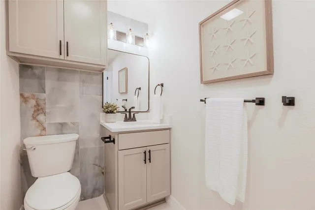a bathroom with a toilet sink and mirror