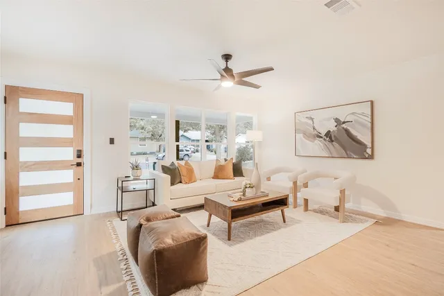a living room with furniture a window and a ceiling fan