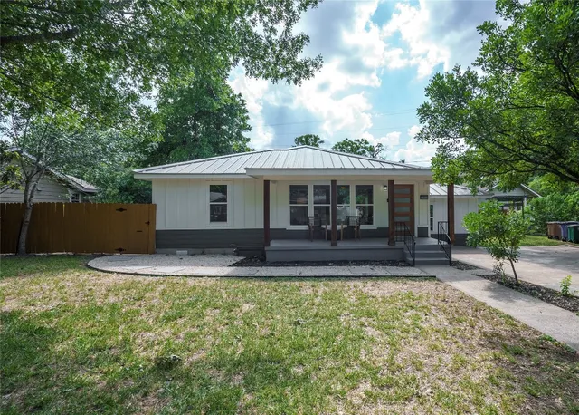 a view of a house with a yard and sitting area