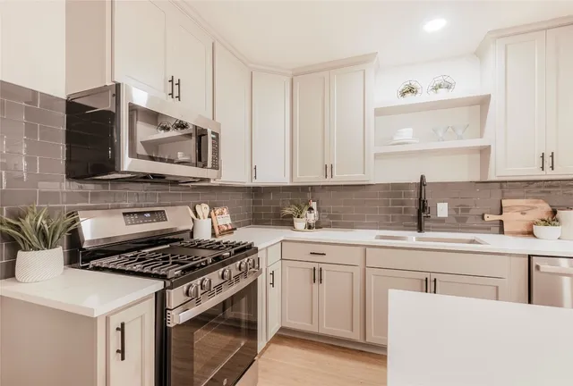 a kitchen with appliances a sink and cabinets