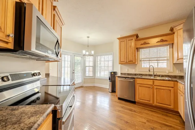 a kitchen with stainless steel appliances granite countertop a stove a sink and a refrigerator