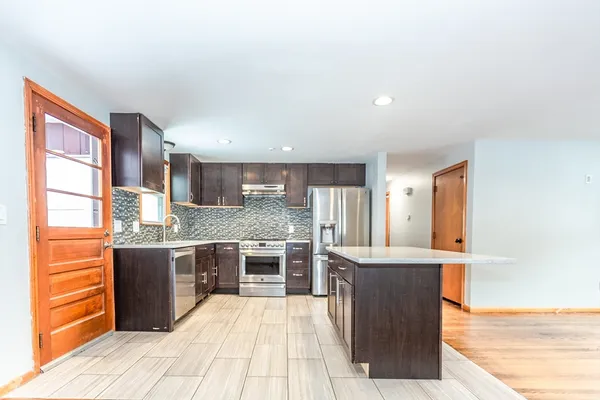 a large kitchen with kitchen island a sink stainless steel appliances and cabinets