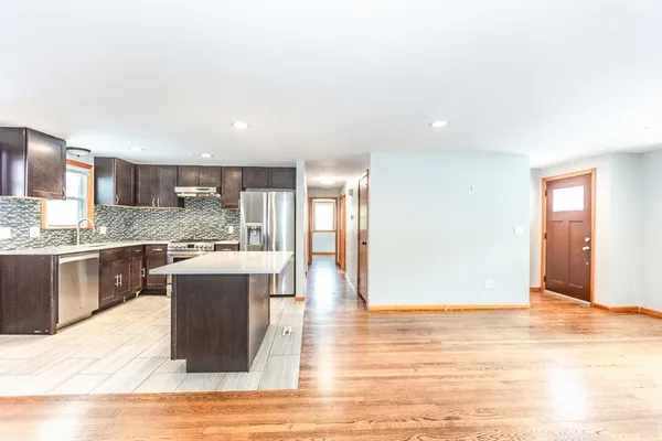 a view of empty room with wooden floor and window