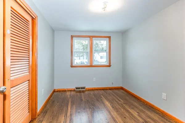 a view of empty room with wooden floor