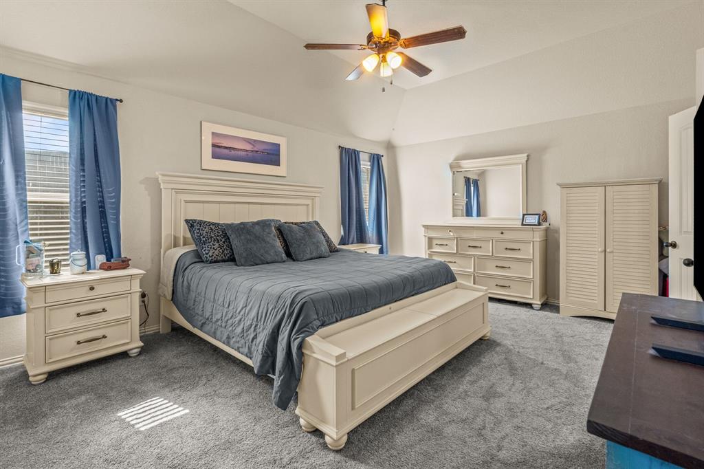 108 Bosque Court Azle, TX 76020 - Photo 23 of 37 a spacious bedroom with a bed and a chandelier