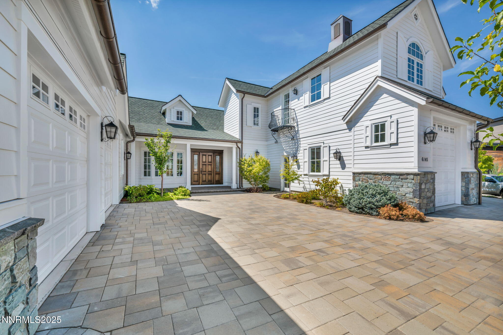 a front view of a house with a yard and potted plants