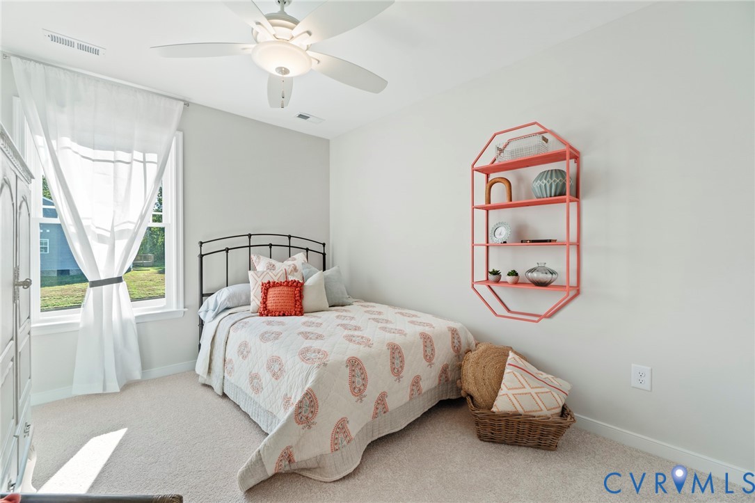 113 Logan Way Tappahannock, VA 22560 - Photo 17 of 33 a bedroom with a bed and a chandelier