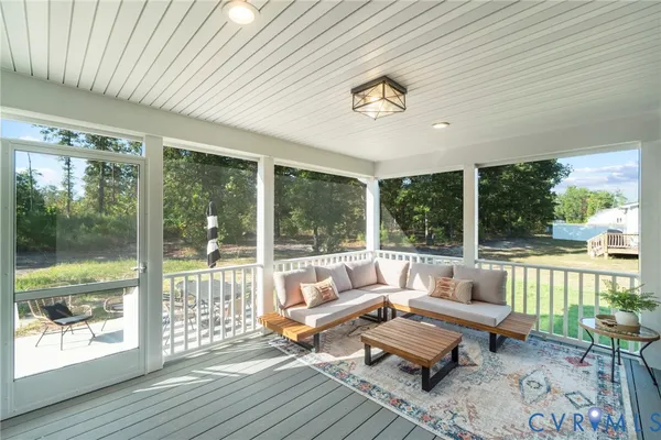 a living room with patio furniture and a floor to ceiling window