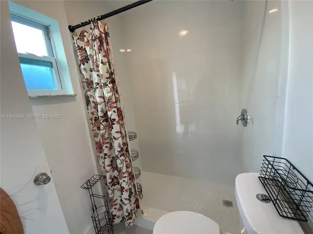a bathroom with a toilet a sink and a shower curtain
