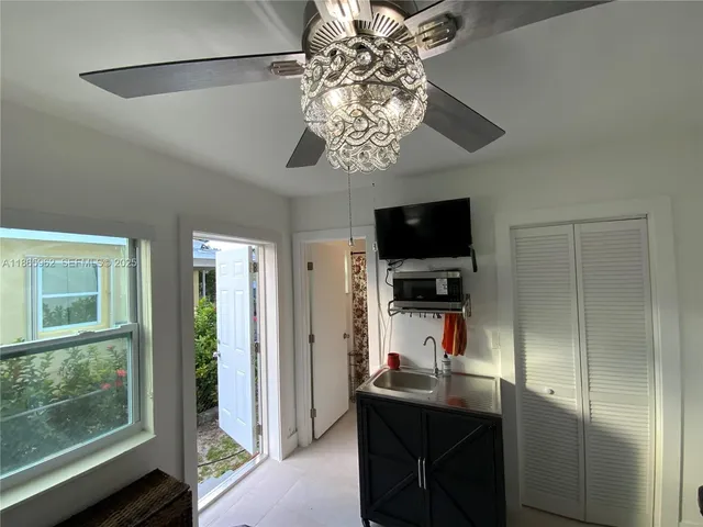 a room with a chandelier and a flat screen tv