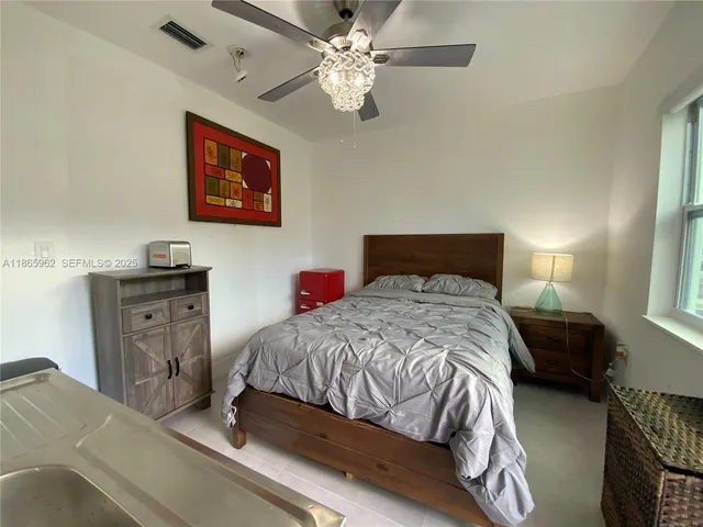 a bedroom with a bed and a chandelier