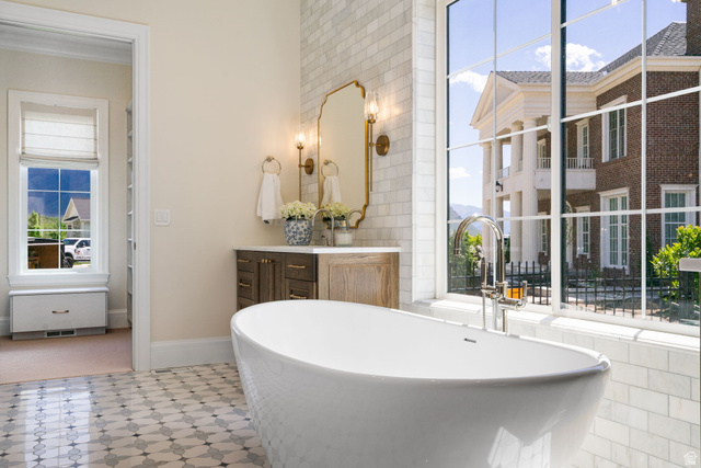 115 East Hidden Ridge Lane, Unit 42 Mapleton, UT 84664 - Photo 26 of 103 Freestanding soaking tub with a floor-mounted faucet, complemented by patterned floor tiles and a subway tile accent wall