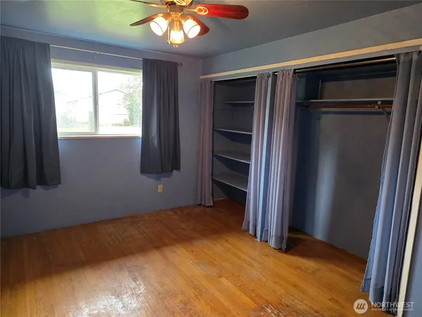 a view of empty room with a fireplace and wooden floor