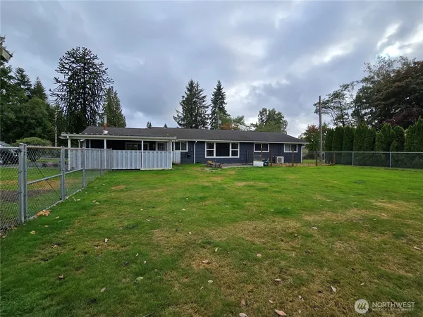 a view of a house with a big yard and a large tree