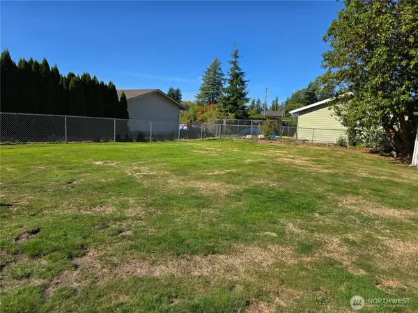 a backyard of a house with plants and wooden fence