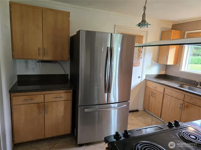 a kitchen with a refrigerator a stove a sink and a window