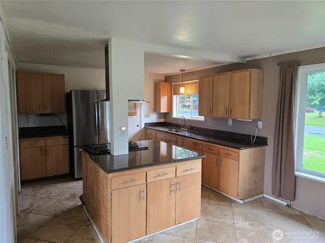 a kitchen with stainless steel appliances granite countertop a refrigerator and a sink