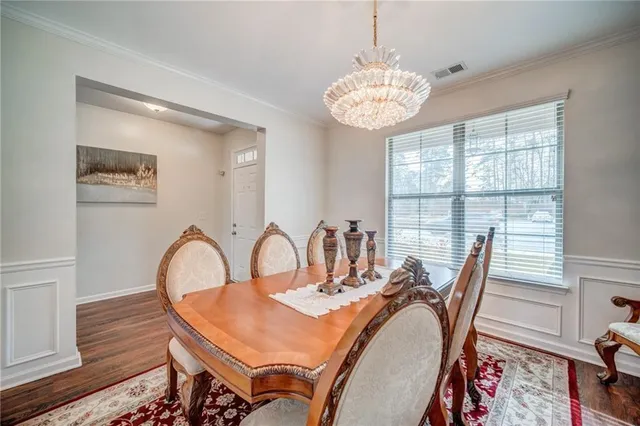a view of a dining room with furniture a chandelier and wooden floor