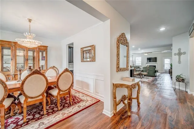 a view of a dining room with furniture a chandelier and wooden floor