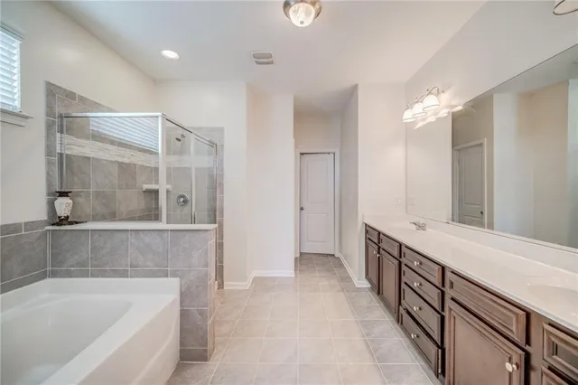 a spacious bathroom with a tub sink and mirror