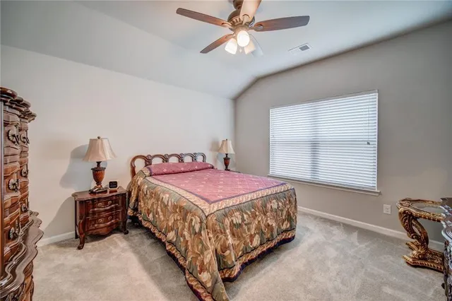 a bedroom with a bed a chair and a chandelier