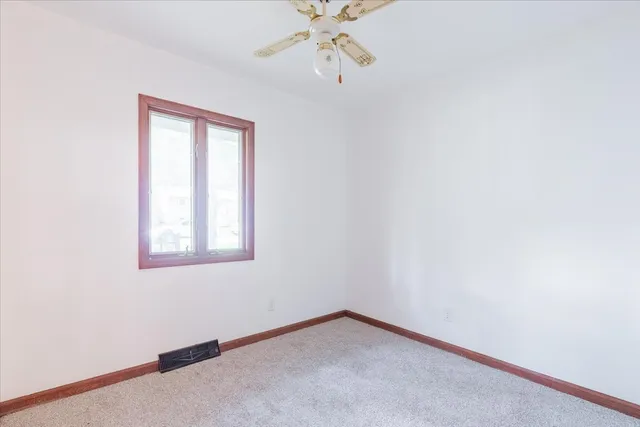 a view of a room with a ceiling fan and a window