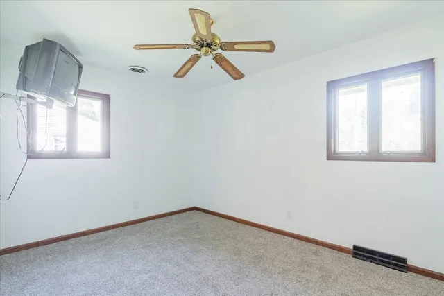 an empty room with a ceiling fan and a window