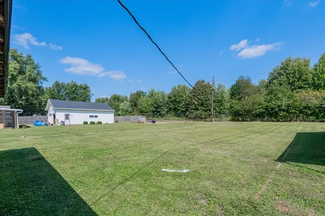 a view of a big house with a big yard plants and large trees