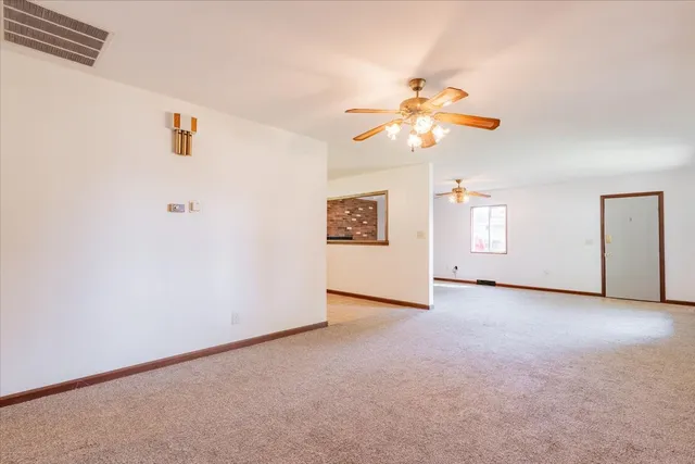 an empty room with closet and a chandelier fan