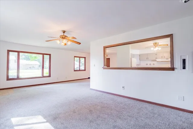 an empty room with windows and a ceiling fan
