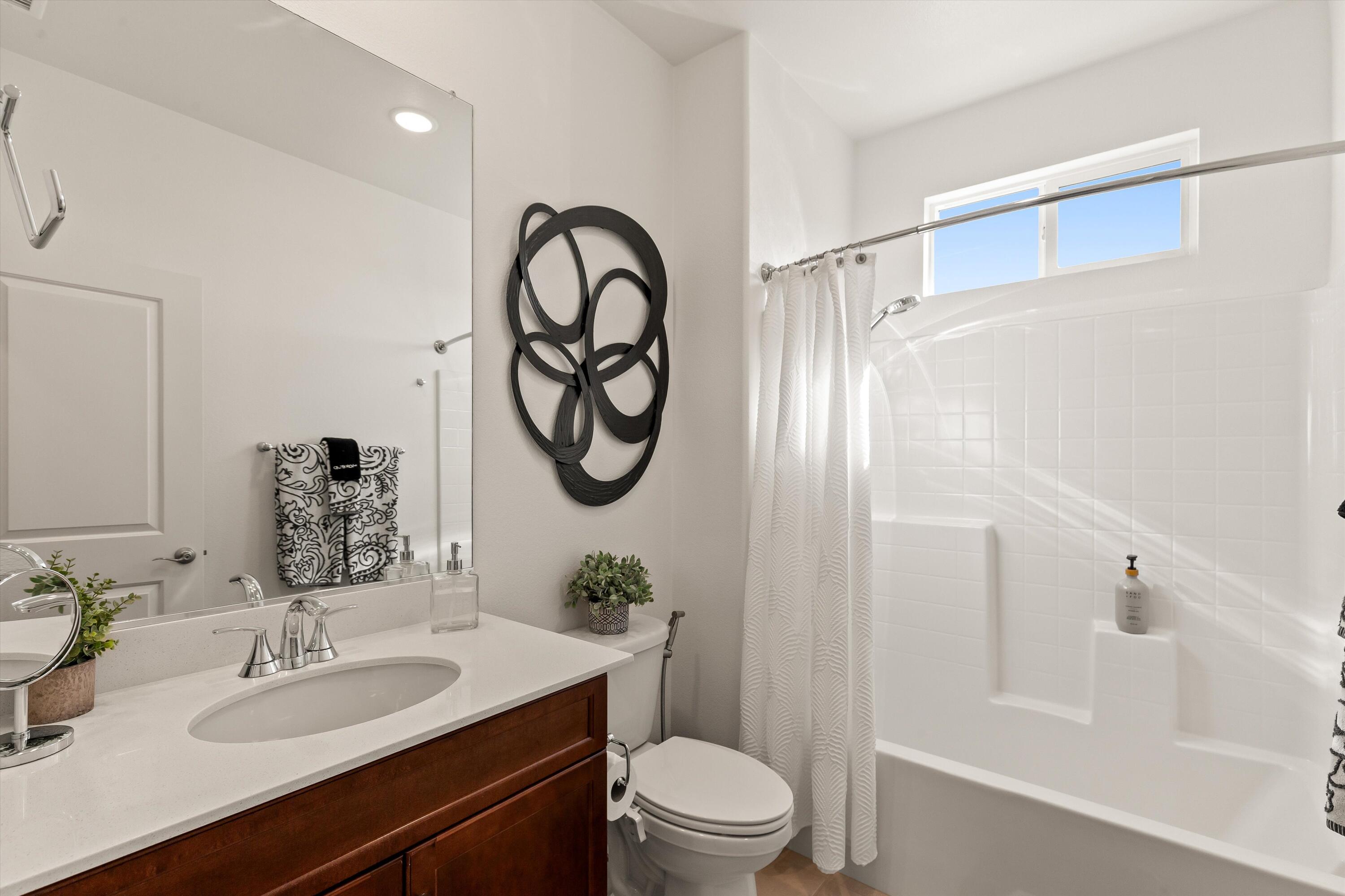 42940 Ascona Lane Indio, CA 92203 - Photo 15 of 36 a bathroom with a granite countertop sink a toilet a mirror a vanity and shower