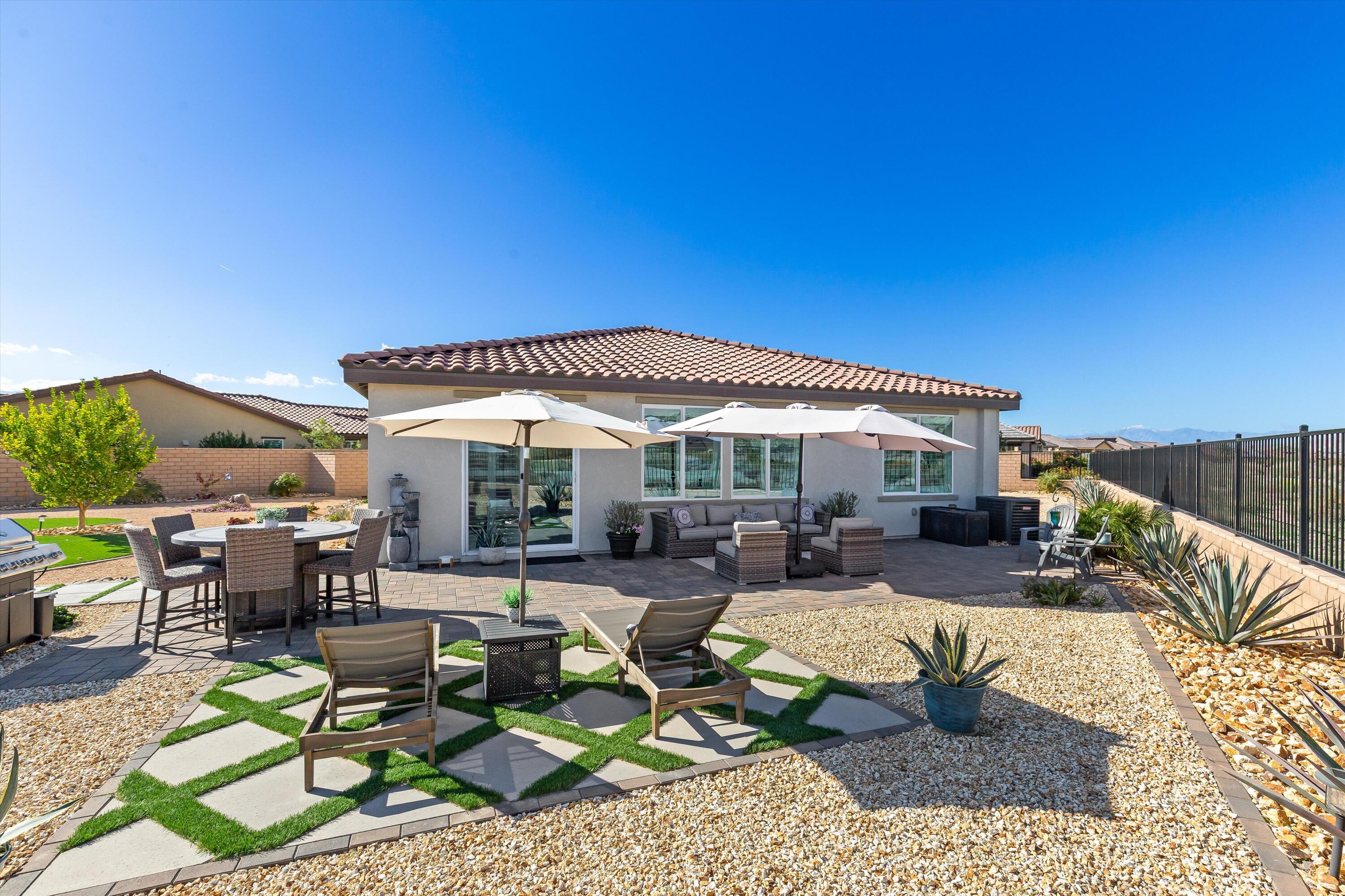 42940 Ascona Lane Indio, CA 92203 - Photo 2 of 36 a view of a patio with couches table and chairs under an umbrella with a barbeque