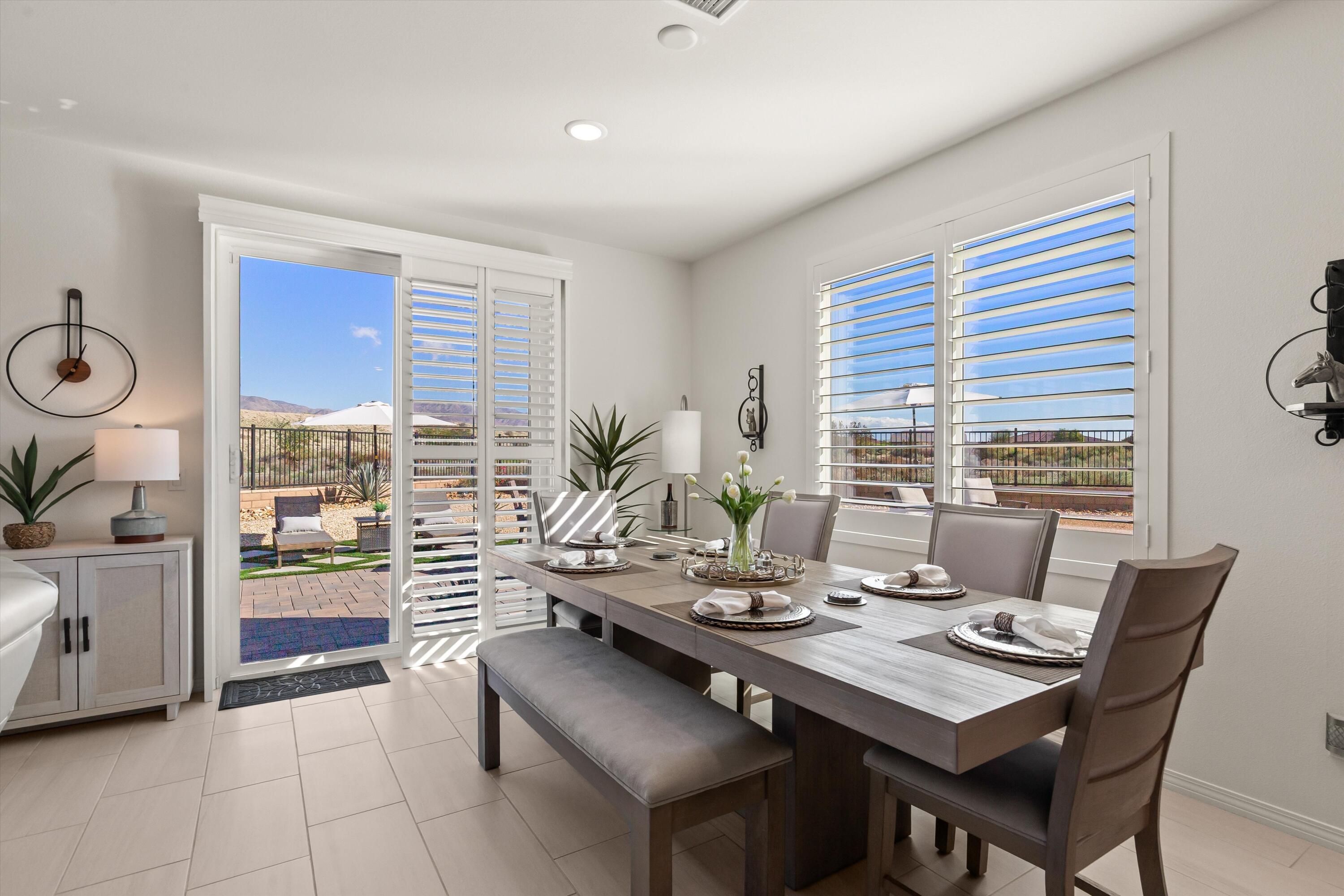 42940 Ascona Lane Indio, CA 92203 - Photo 9 of 36 a view of a dining room and livingroom with furniture wooden floor and a window