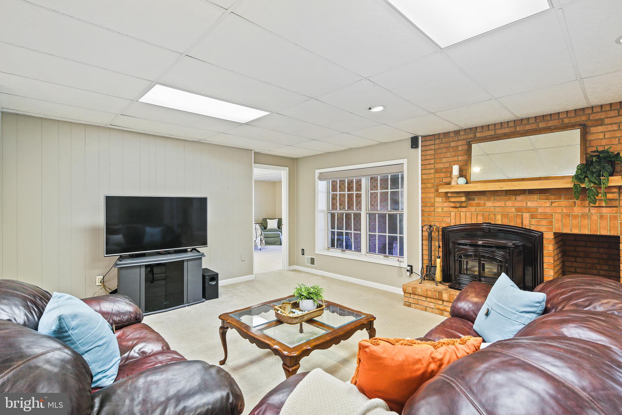 12148 Mt Albert Road Ellicott City, MD 21042 - Photo 39 of 70 a living room with furniture a fireplace and a flat screen tv
