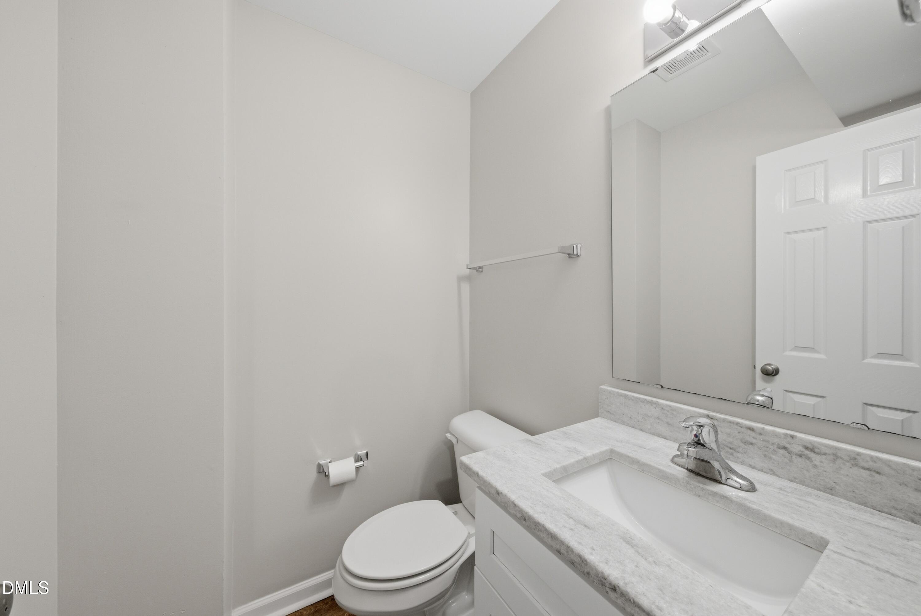 201 Tonylee Court, Unit A Raleigh, NC 27603 - Photo 20 of 30 a bathroom with a granite countertop sink a toilet and a mirror