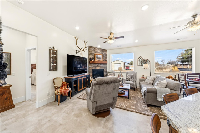 357 East Main Street Enterprise, UT 84725 - Photo 14 of 71 Living room featuring a ceiling fan, a stone fireplace, and recessed lighting